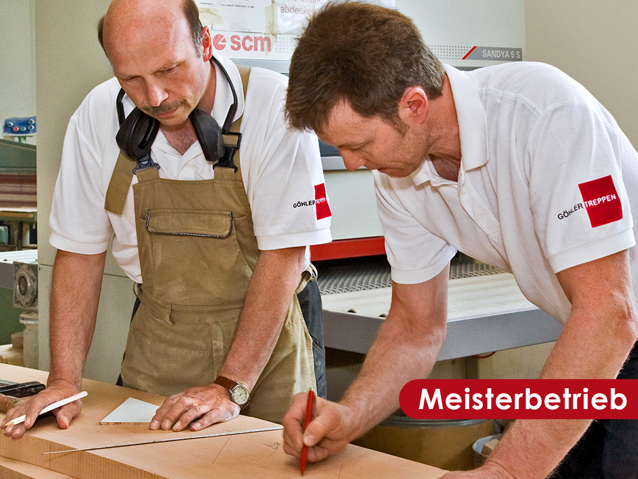 Zwei Handwerker von Göhler Treppen bei der Maßarbeit an einem Werkstück in der Werkstatt